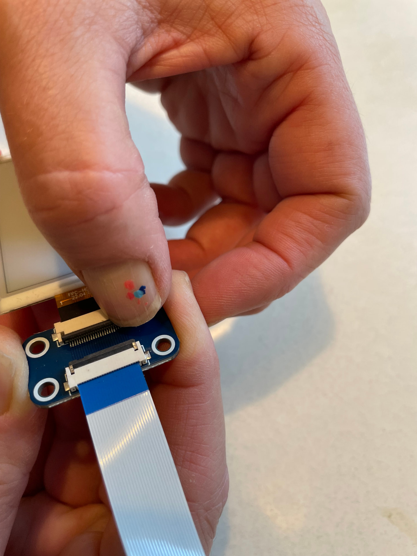 Pressing the connector latch closed over the inserted badge ribbon