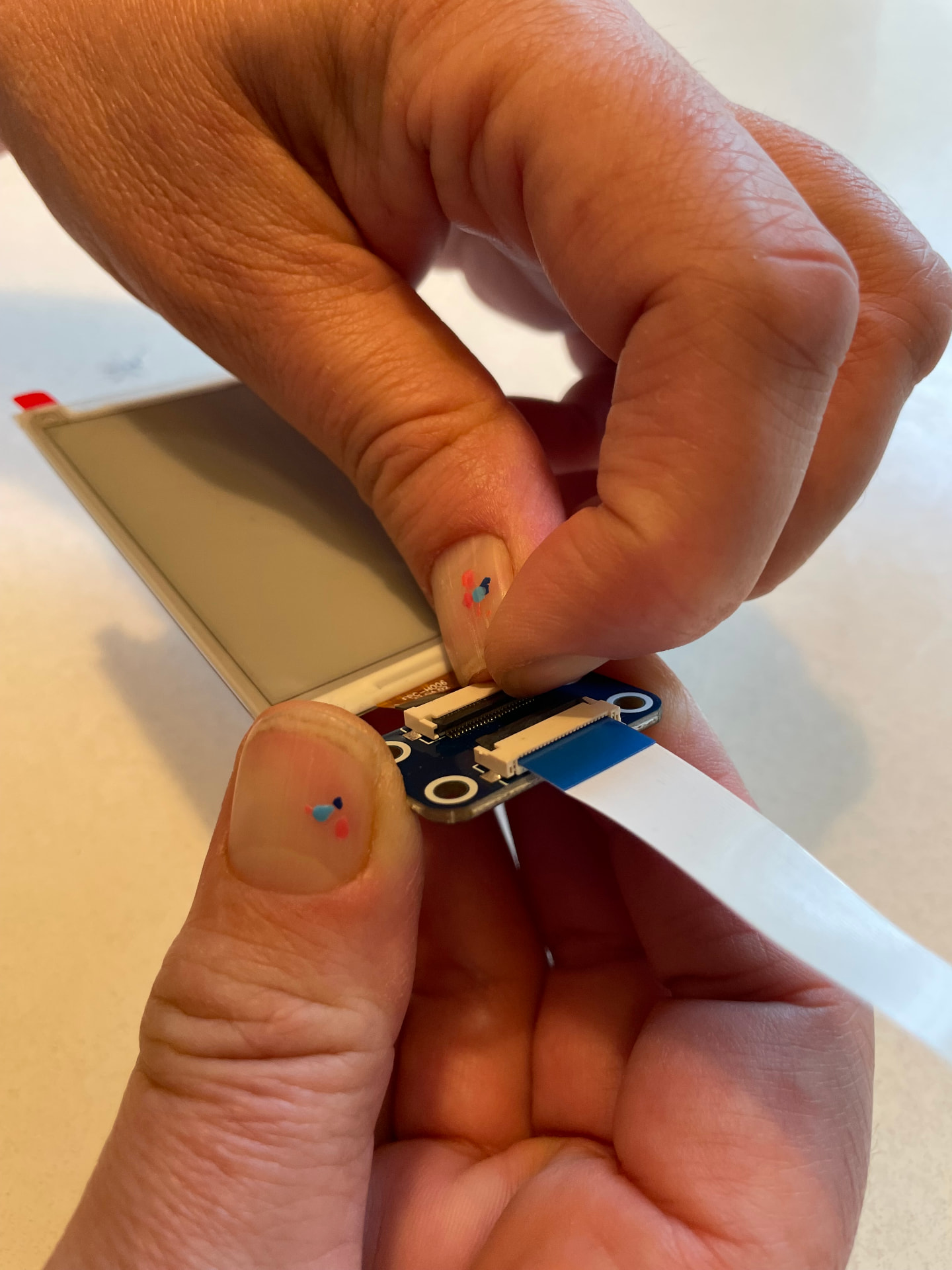 Lifting the connector latch and easing the badge ribbon out of the programmer